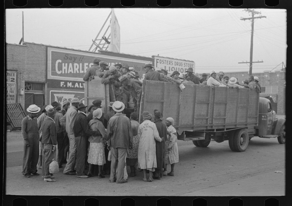 Cotton pickers boarding truck to take them to cotton fields, Pine Bluff, Arkansas by Russell Lee