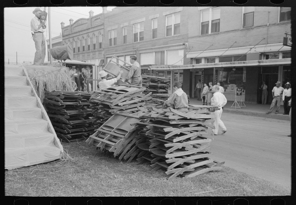 [Untitled photo, possibly related to: Unloading collapsible chairs from track for placement on platform, National Rice…