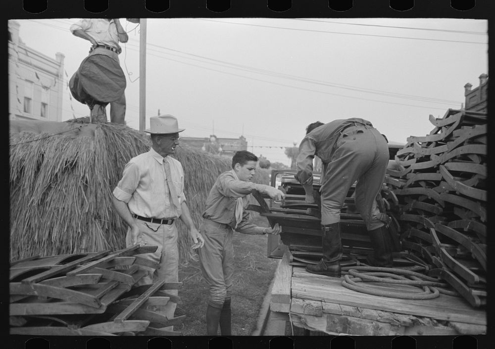 Unloading collapsible chairs from track for placement on platform, National Rice Festival, Crowley, Louisiana by Russell Lee