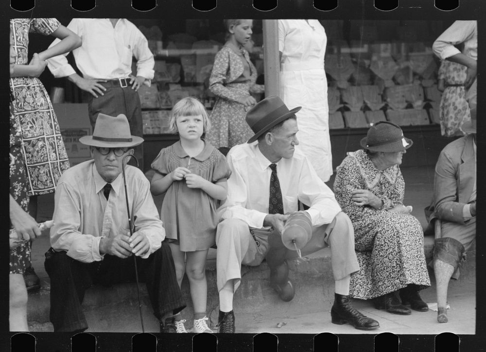 People sitting on sidewalk waiting for parade, National Rice Festival, Crowley, Louisiana by Russell Lee