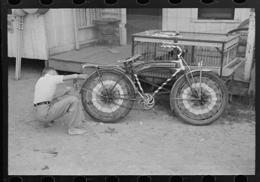 [Untitled photo, possibly related to: Boy decorating bicycle for entering contest for best decorated bicycle, National Rice…
