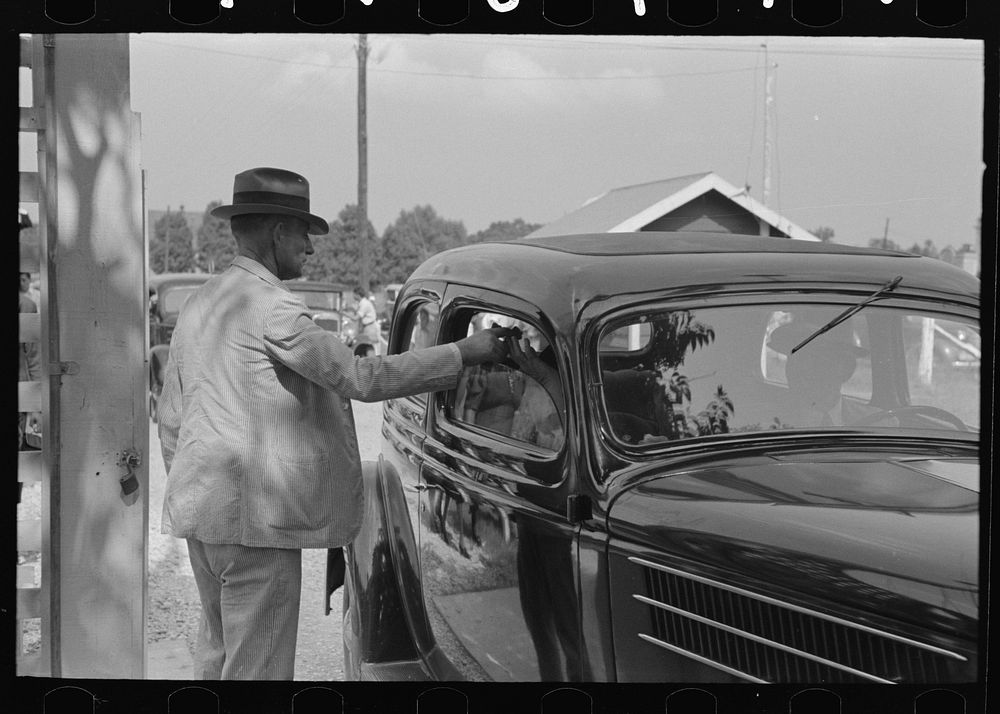 Ticket taker at gate, state fair, Donaldsonville, Louisiana by Russell Lee
