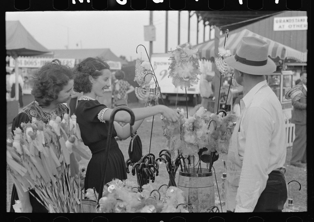 Girl buying cane from concessionaire, Donaldsonville, Louisiana, state fair by Russell Lee