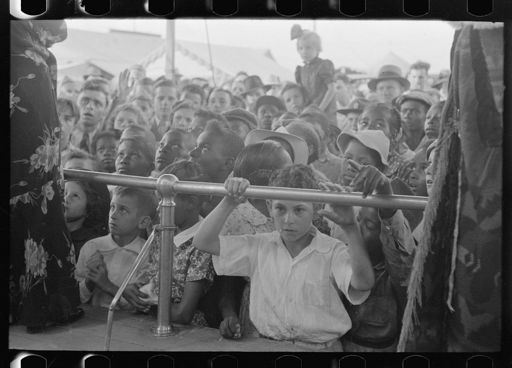 [Untitled photo, possibly related to: Children listening to barker at sideshow, state fair, Donaldsonville, Louisiana] by…
