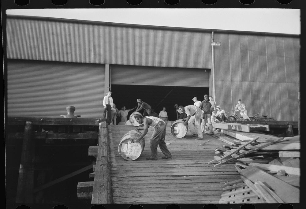 [Untitled photo, possibly related to:  stevedores "snaking" drums down ramp to boat, New Orleans, Louisiana] by Russell Lee