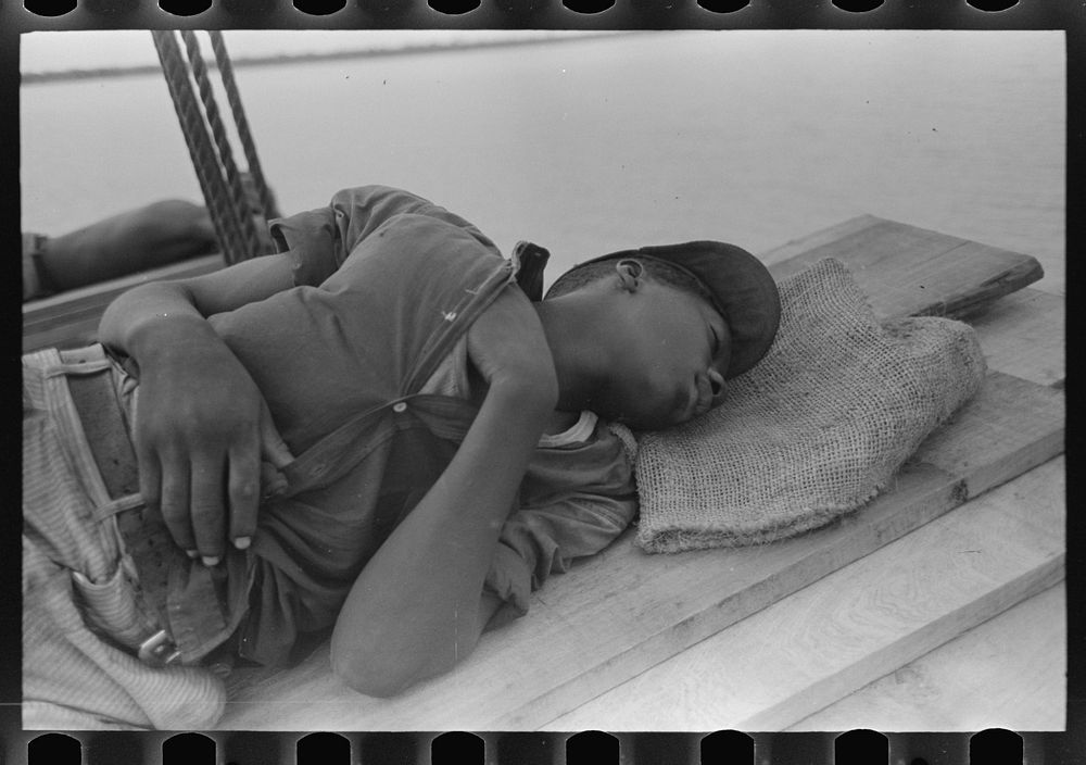  stevedore asleep on lumber in bow of boat El Rito, Lousiana by Russell Lee