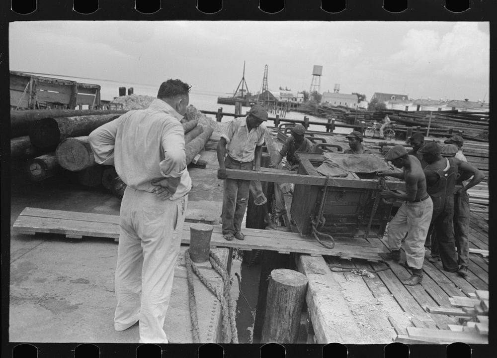 stevedores loading stove onto packet boat under supervision of captain, Burrwood, Louisiana by Russell Lee