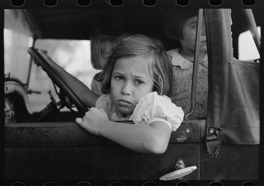 Child of farmer sitting in automobile waiting for father to come out of general store, Jarreau, Louisiana by Russell Lee