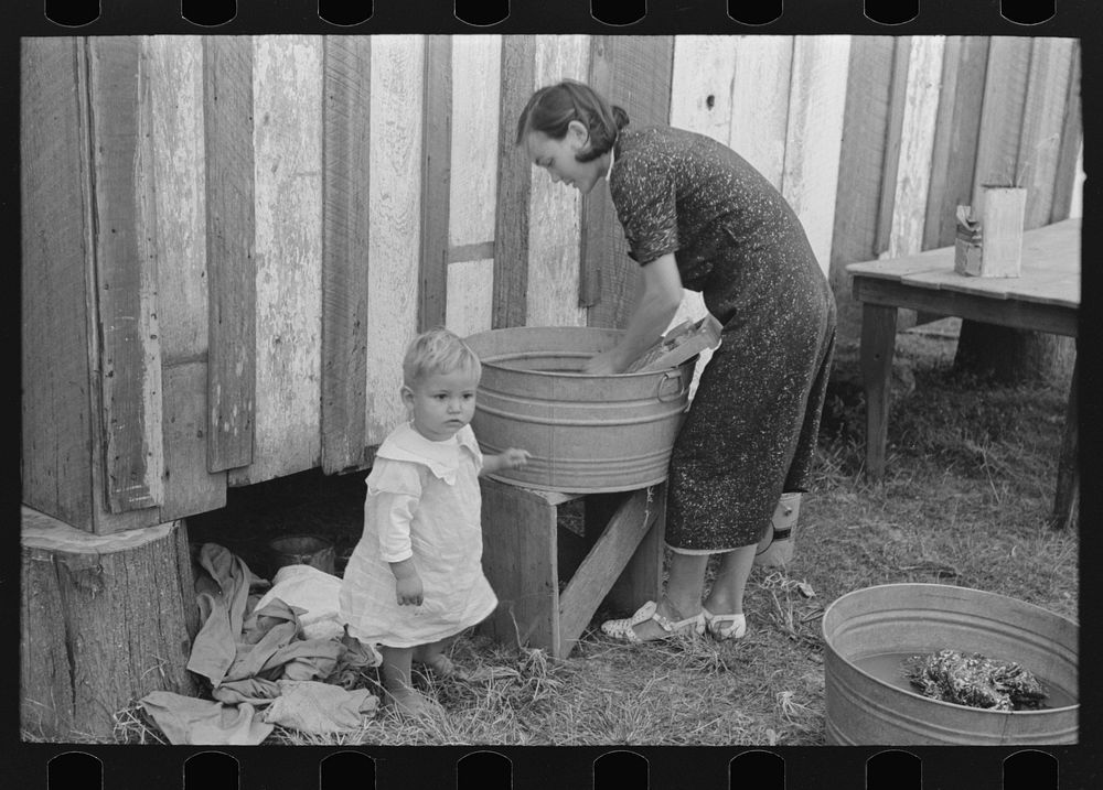 Farmer's wife washing clothes and watching son at same time. Note construction of house. Near Morganza, Louisiana. Mrs. W.E.…