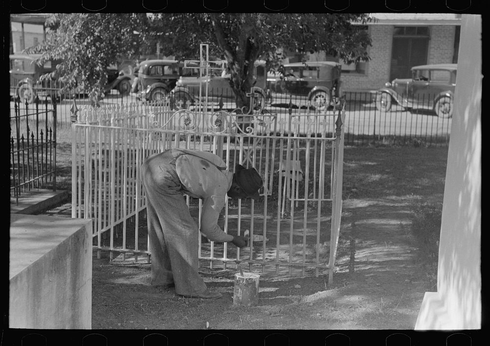 [Untitled photo, possibly related to: Woman decorating family burial vaults in cemetery at New Roads, Louisiana on All…