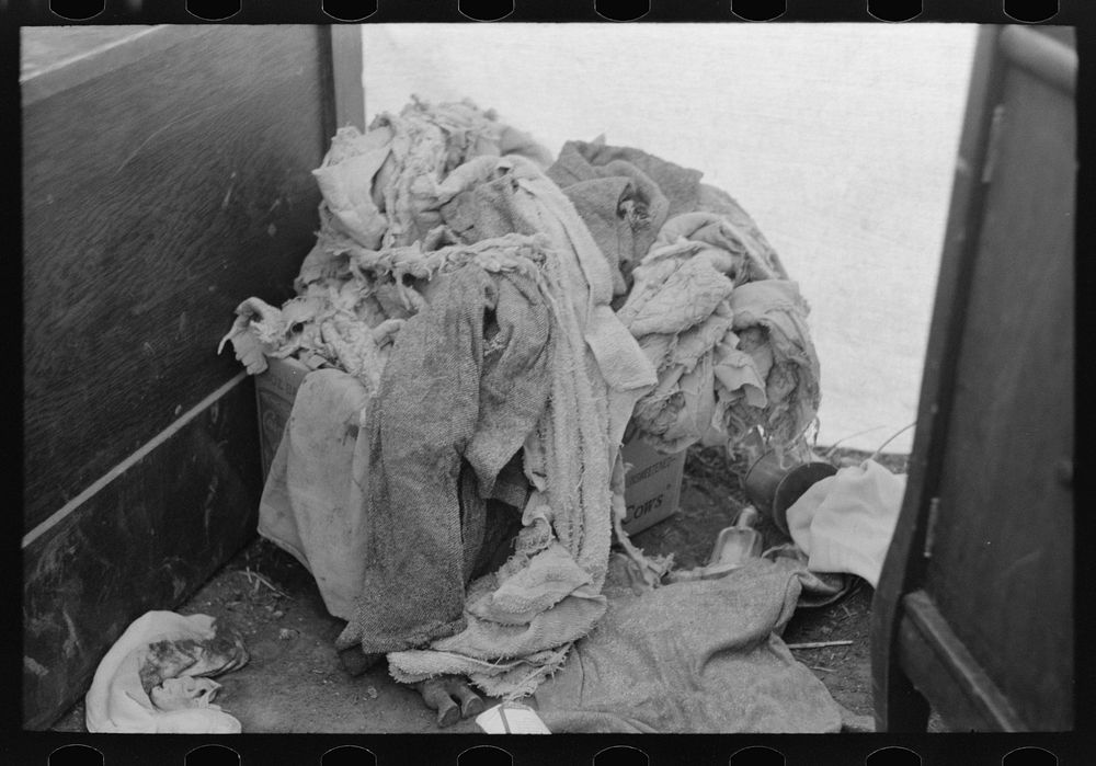 Pile of raggedy clothing in tent home of migrants near Harlingen, Texas by Russell Lee