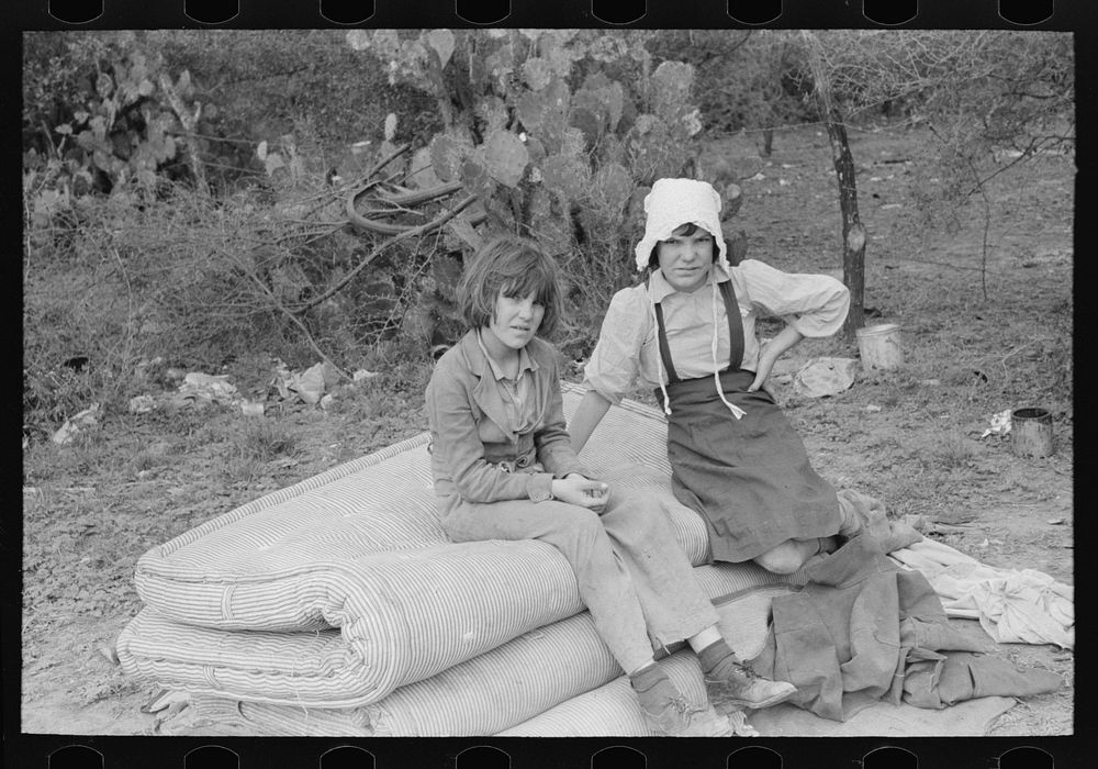 Children of white migrants from west Texas sitting on mattresses just unloaded from trailer. Harlingen, Texas by Russell Lee