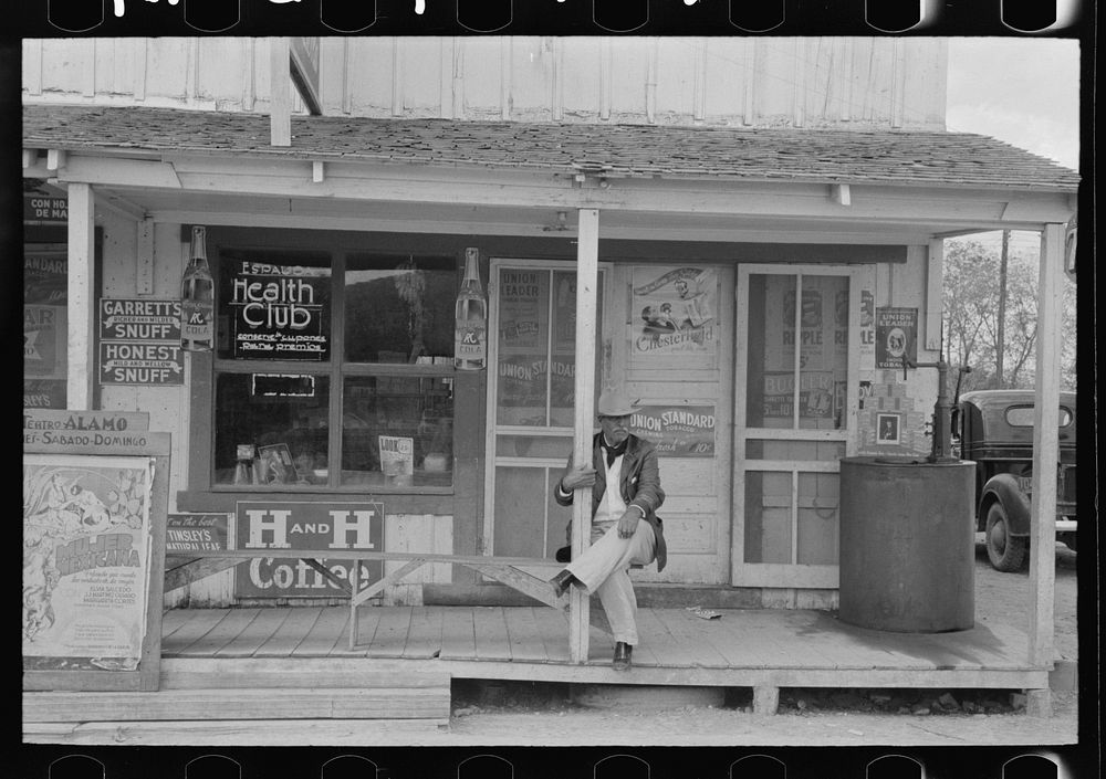 Mexican sitting on porch of store, Alamo, Texas by Russell Lee