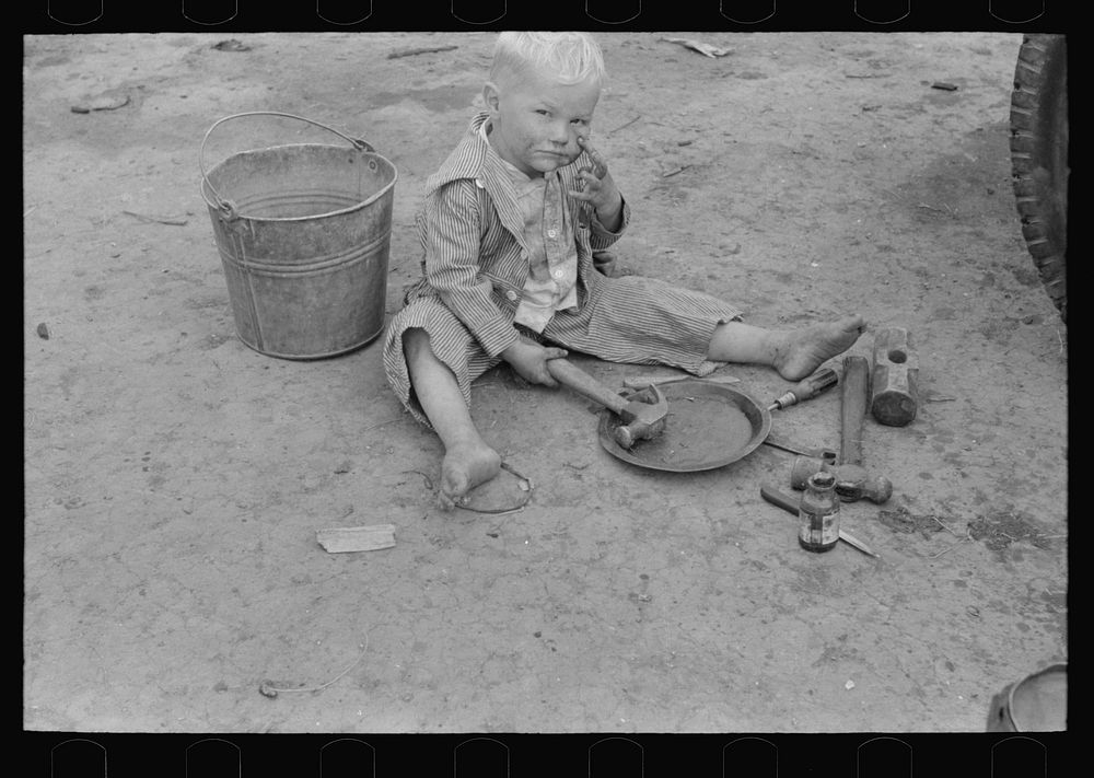 Child of white migrant worker playing with automobile tools near Harlingen, Texas by Russell Lee