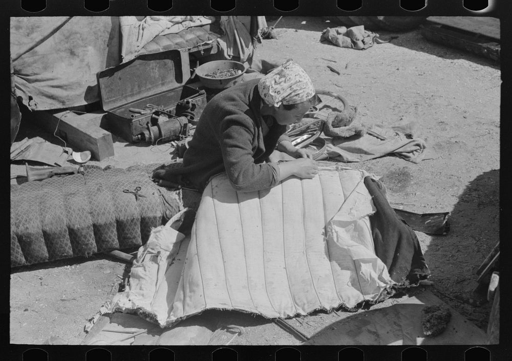 Wife of migrant auto wrecker sewing seat cushion of wrecked auto, Corpus Christi, Texas by Russell Lee
