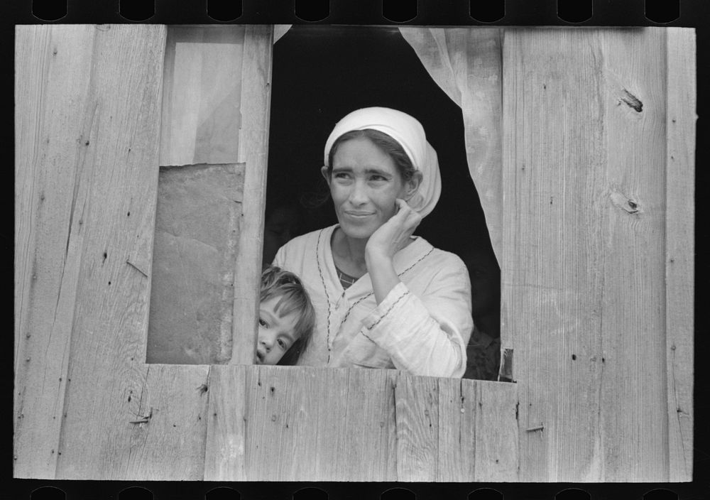 Mexican woman and son looking out of window into corral, San Antonio, Texas by Russell Lee