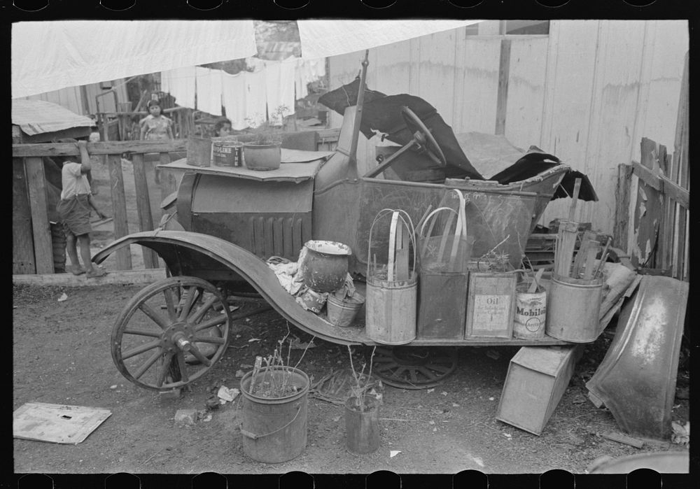Old automobile with various potted flowers, Mexican district, San Antonio, Texas by Russell Lee
