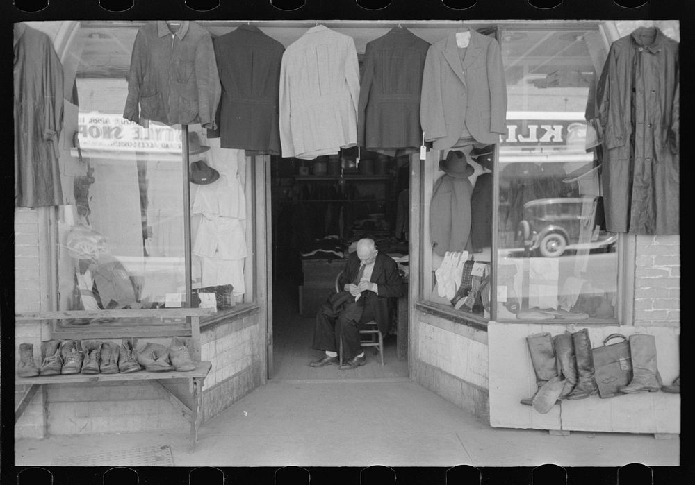 [Untitled photo, possibly related to: Clothing store with tailor in doorway, Mexican district, San Antonio, Texas] by…