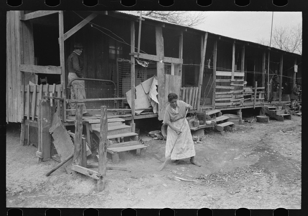 Corral, woman sweeping up trash, San Antonio, Texas by Russell Lee