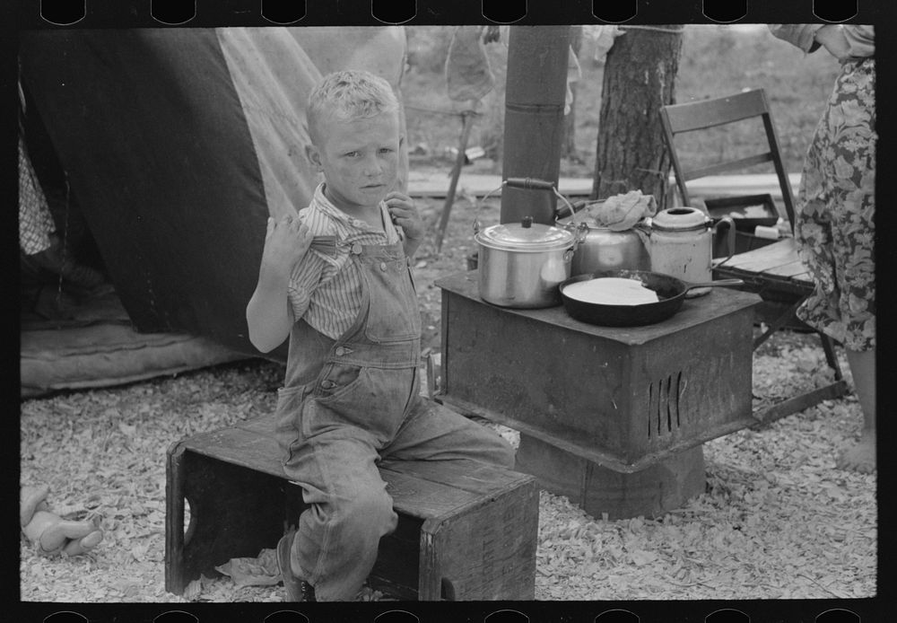 Child of migrant strawberry picker in front of tent home near Hammond, Louisiana by Russell Lee