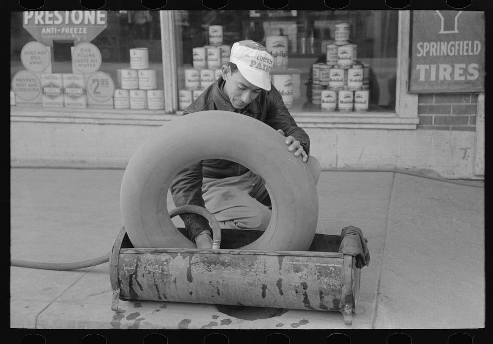 Man inspecting inner tube for air leaks, Eagle Pass, Texas by Russell Lee