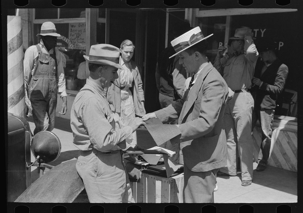 Salesman displaying sample of suit material to farmer, Hammond, Louisiana by Russell Lee