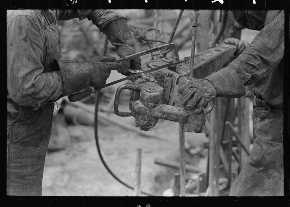 Detail of oil workers repairing pipe wrench; notice gloves. Oil well, Kilgore, Texas by Russell Lee