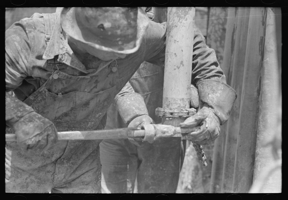 [Untitled photo, possibly related to: Tightening the nipple on the end of drill pipe oil field, Kilgore, Texas. This part of…