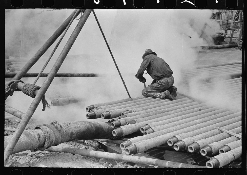 Oil field worker, probing in slush pit, Kilgore, Texas by Russell Lee