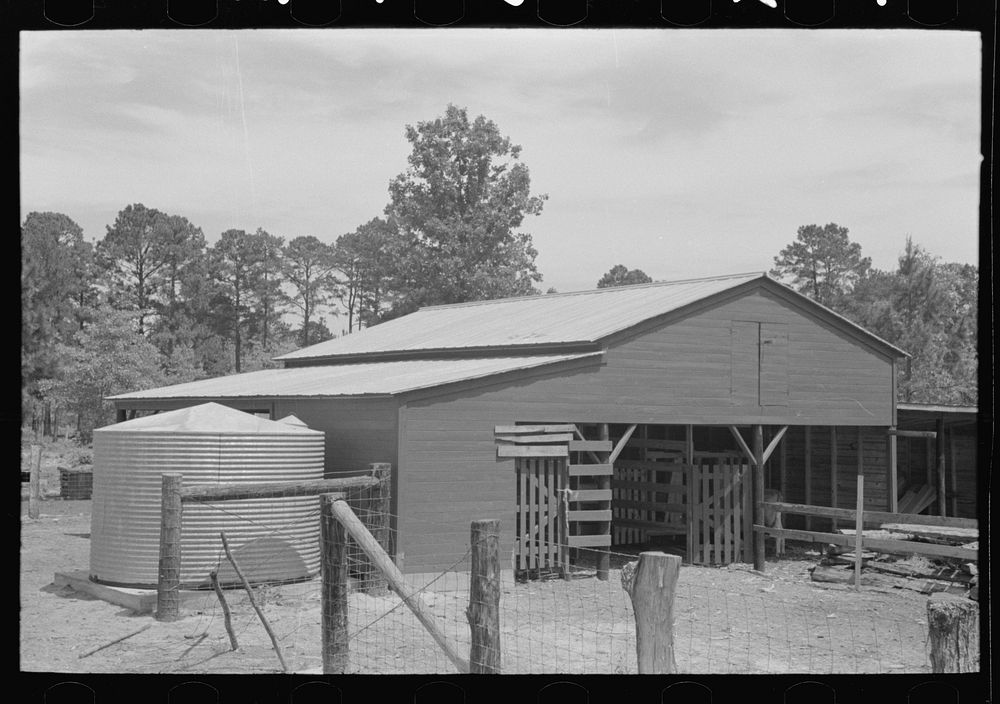 Barn and water tank of FSA (Farm Security Administration) client, Sabine Farms, Marshall, Texas by Russell Lee