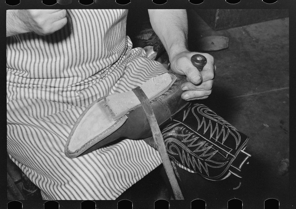 Attaching piece of leather in arch of sole by means of wooden pegs. Cowboy bootmaking shop, Alpine, Texas by Russell Lee