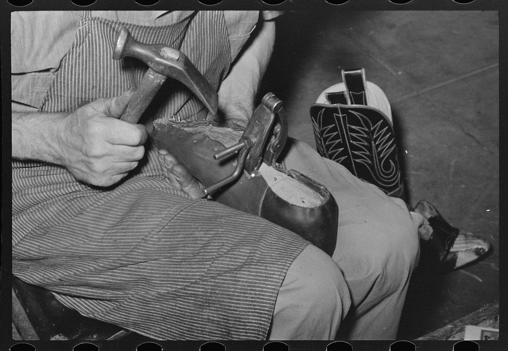 Nailing foot of boot to sole, in order to hold in place when sewing foot to welt. These nails are removed after sewing.…