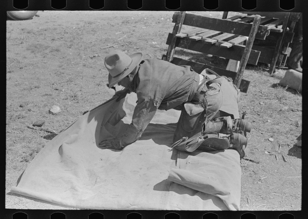 Tying the bedroll. Bunk of the cowboy on the range. Cattle ranch near Marfa, Texas by Russell Lee