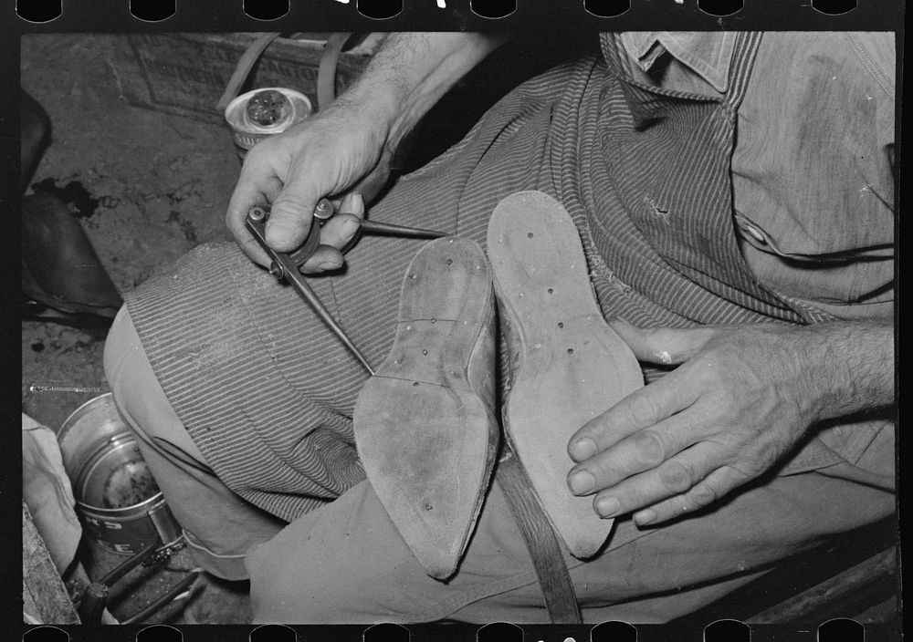 Calipering inner sole of boot to see if it matches pattern, Boot shop, Alpine, Texas by Russell Lee
