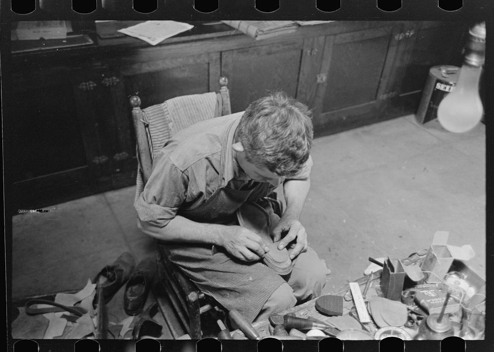 [Untitled photo, possibly related to: Applying glue to heel before putting on another piece of leather. Bootmaking shop…