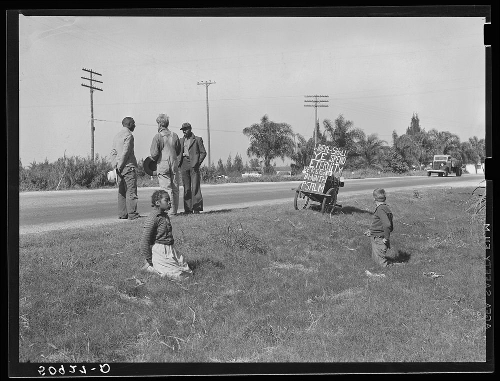 Traveling preacher talking to two es, one whose wife is sick and needs help. Belle Glade, Florida. Sourced from the Library…