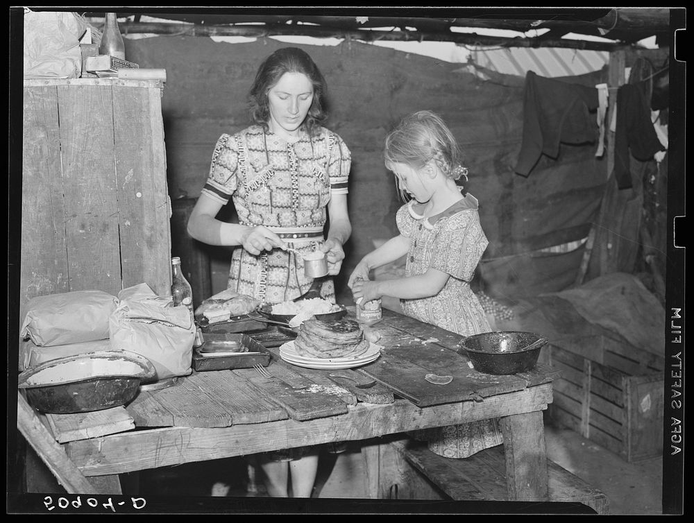 Woman migrant packinghouse worker and her oldest child fixing supper. She has three other children. Belle Glade, Florida.…