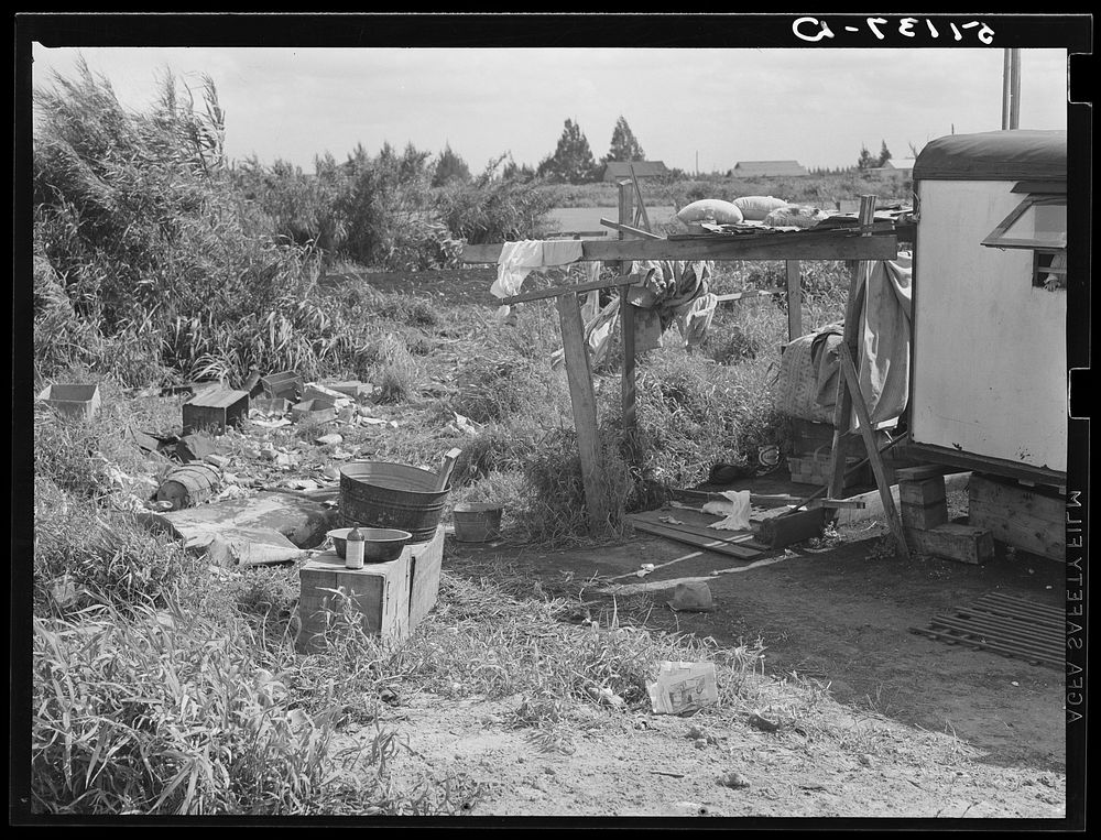 Migratory packinghouse workers' trailer (see 51118-D) showing garbage disposal and no toilet facilities. Belle Glade…