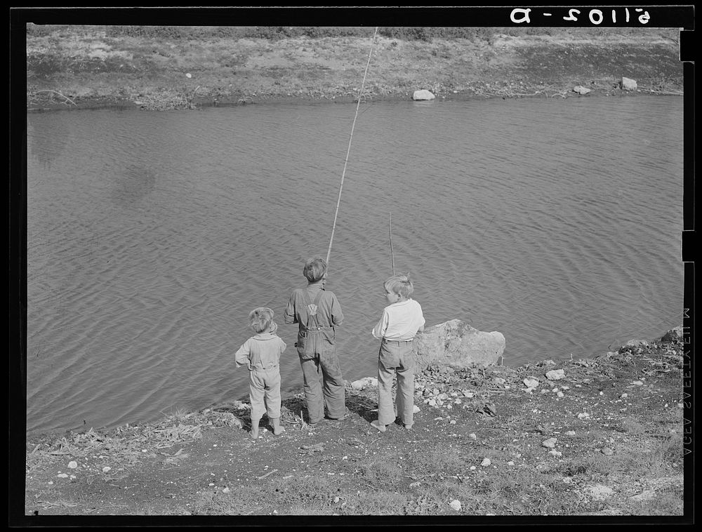 Migrant packinghouse workers' children fishing in canal near Belle Glade, Florida. Sourced from the Library of Congress.