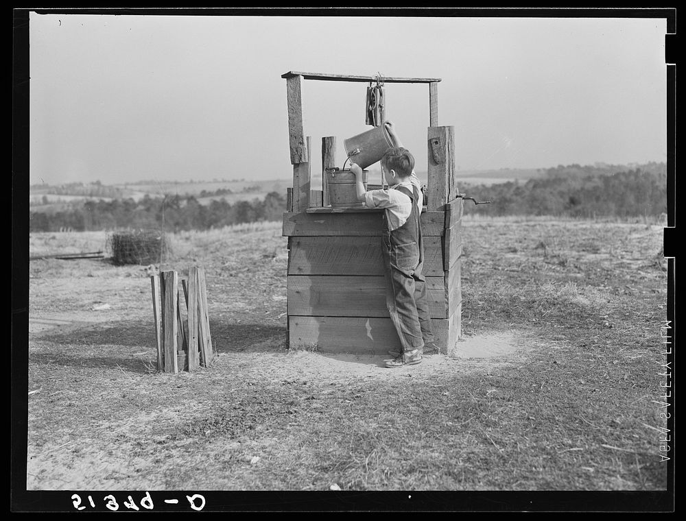 Lewis boy getting water from old well, typical of most in area where wells are very often polluted. Coffee County, Alabama.…