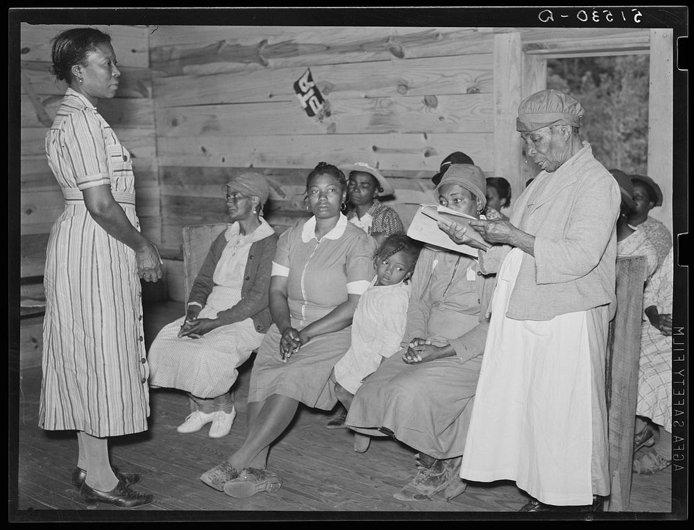 Juanita Coleman (Miss or Mrs.), teacher and NYA (National Youth Administration) leader, listening to one of her pupils in…