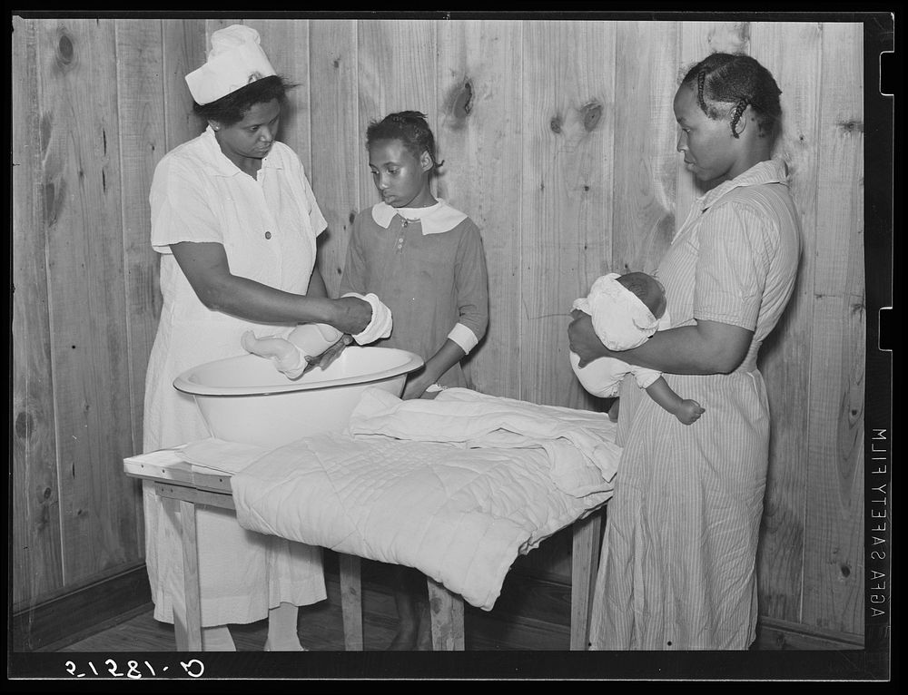 Nurse Shamburg demonstrates care of baby bottles to Mrs. Paralee Coleman and Marie. Mothers have to work in field and…
