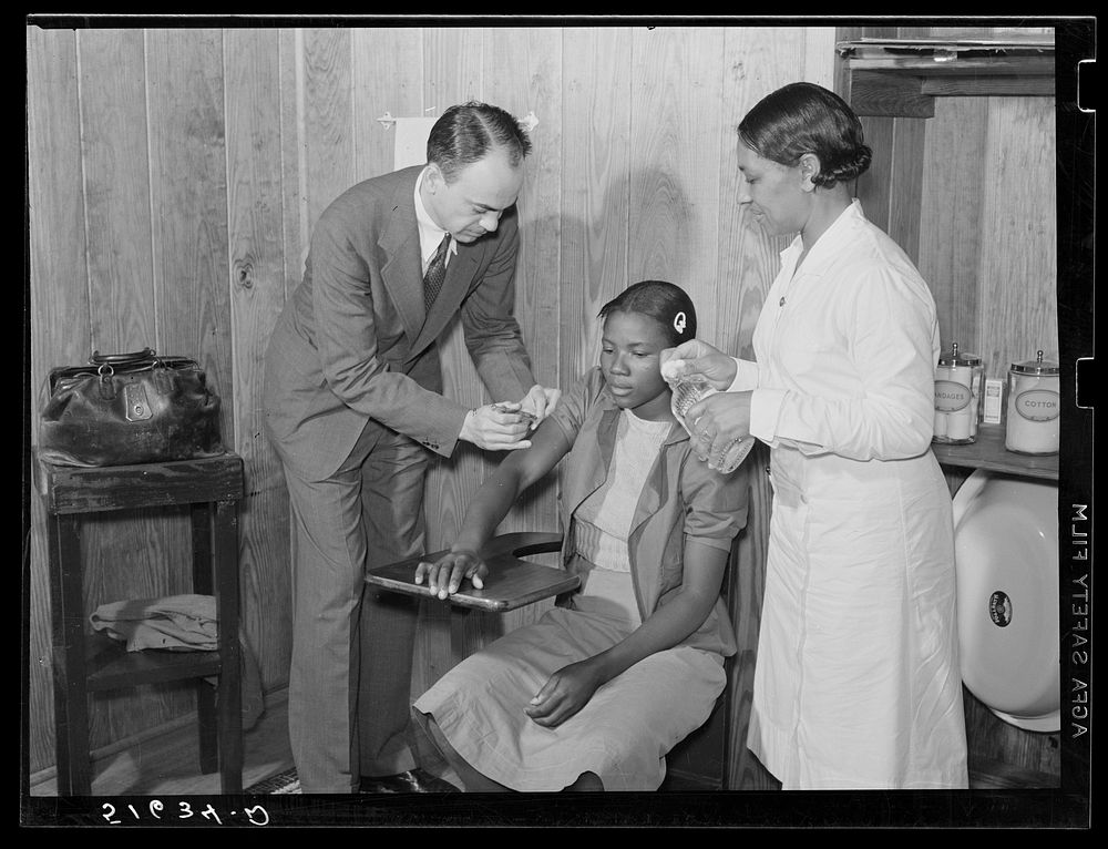 Dr. Thomas M. Adams, one of cooperative medical plan members, with project nurse Lillie May McCormick giving typhoid shot to…