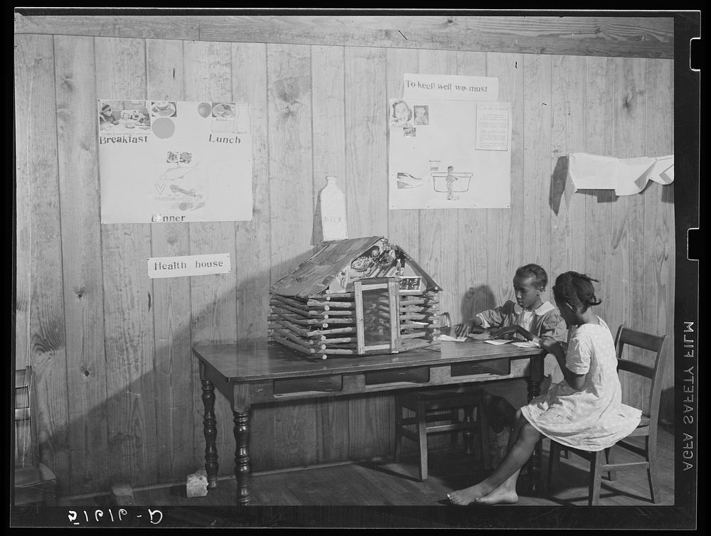 Juanita Eygran and Jeredine Burman cutting out health pictures to paste on second and third grades health house. Flint River…
