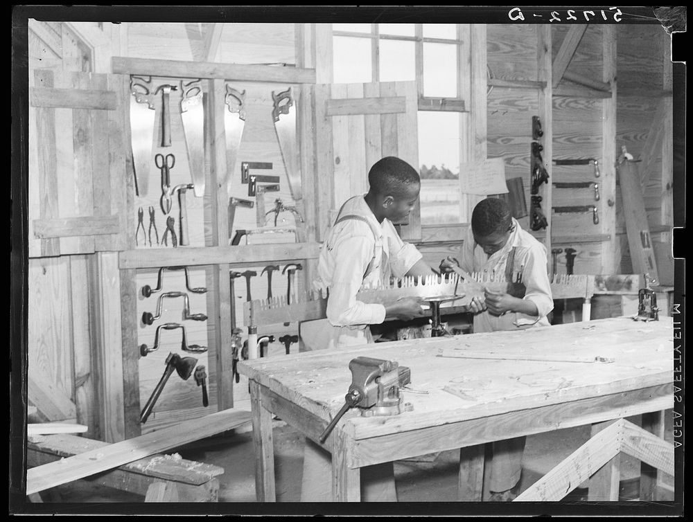 J.W. West and John Young sharpening crosscut saw in school shop class. Flint River Farms, Georgia. Sourced from the Library…