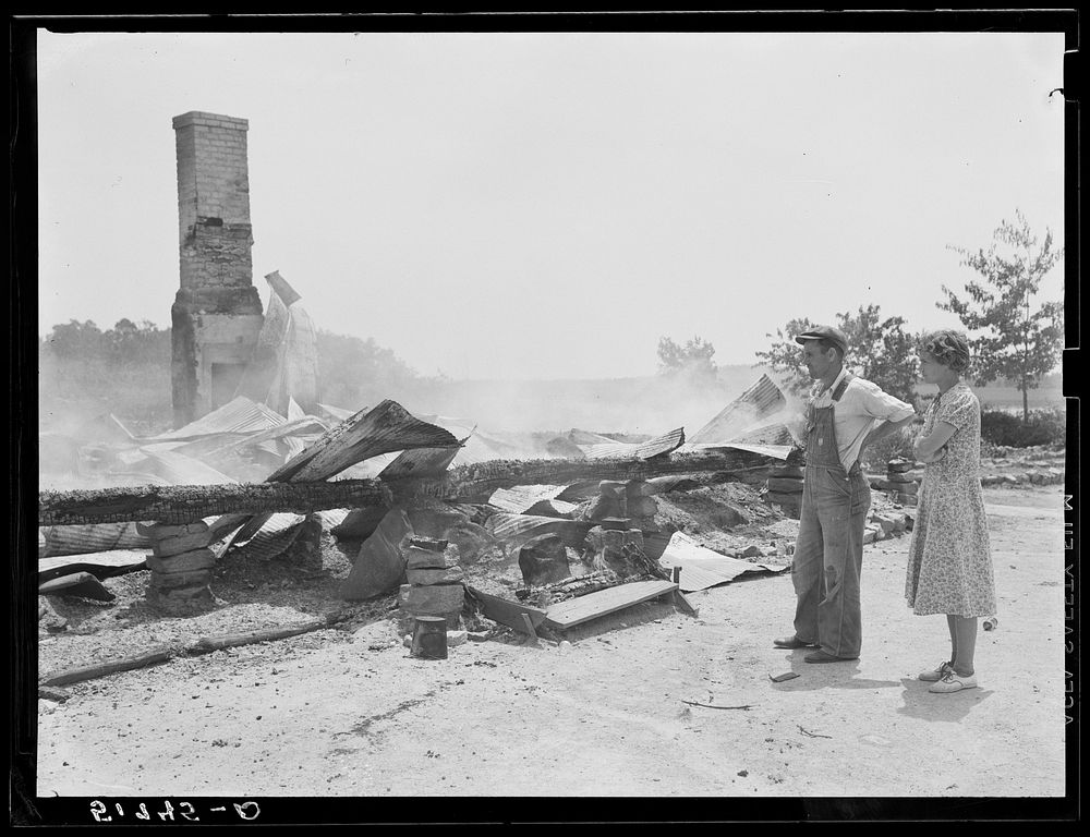 Tenant farmer and wife looking at ruins of home burned to ground. Greene County, Georgia. Sourced from the Library of…
