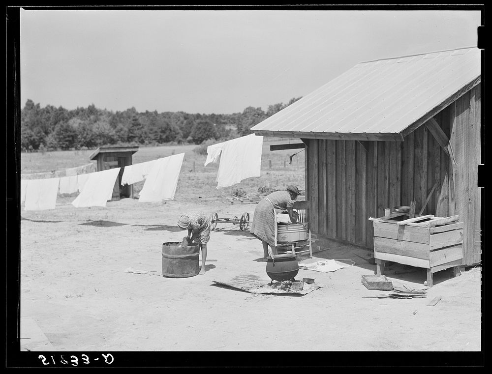 [Untitled photo, possibly related to: Lonny Smith's wife and daughter doing laundry by new smoke and washhouse in their…