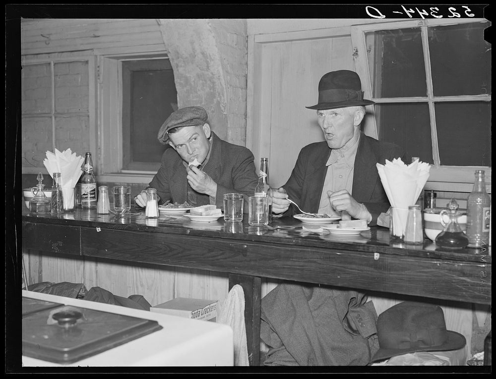 Farmers eating in cafe under tobacco warehouse during auction sale. Durham, North Carolina. Sourced from the Library of…
