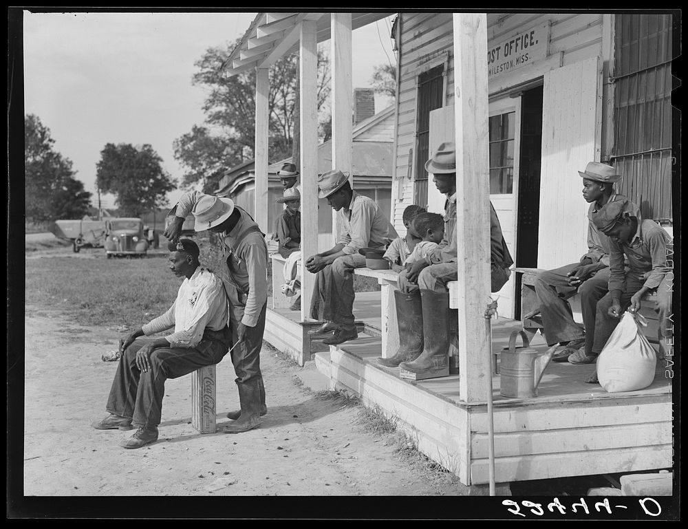 [Untitled photo, possibly related to: es cut each other's hair in front of plantation store after being paid off on…