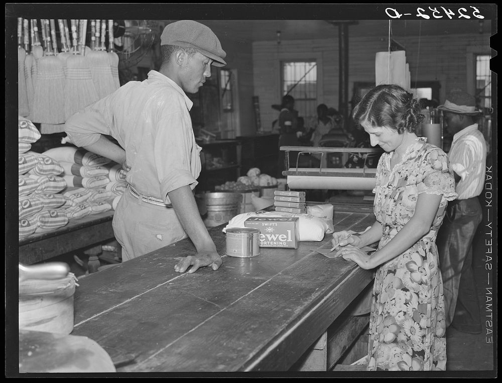  wagehand purchasing groceries after being paid off on Saturday in plantation store. Mileston Plantation, Mississippi Delta.…